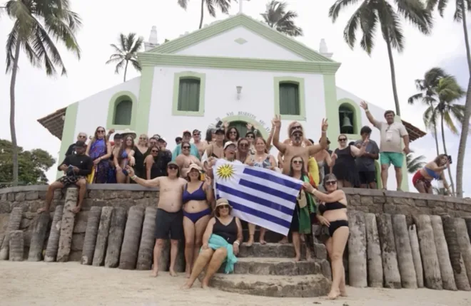 Grupo de viajeros junto a una iglesia frente a la playa